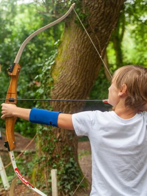 A boy aiming an arrow at a target